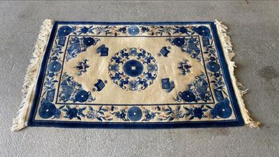 un tapis bleu et blanc posé sur un sol en béton