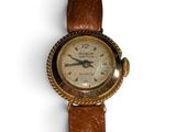 une vieille montre-bracelet avec un bracelet en cuir marron sur un fond blanc