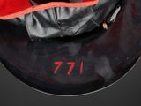 a black bag with a red handle on a black plate