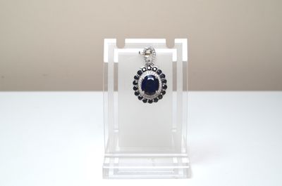 silver and blue stone earrings on clear acrylic display stand