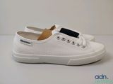 the white shoes are on a white surface with a black stripe