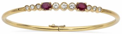 un gros plan d'une bague en or jaune sertie de rubis et de diamants