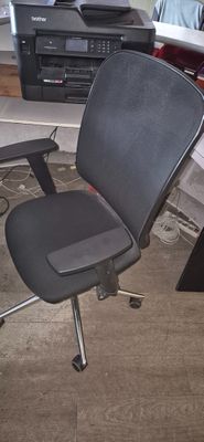 une chaise de bureau noire assise devant un bureau d'ordinateur