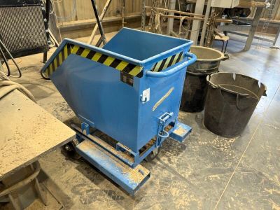 un grand conteneur bleu posé sur un chariot dans une pièce