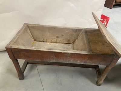 une vieille boîte en bois avec un couvercle, posée sur une table