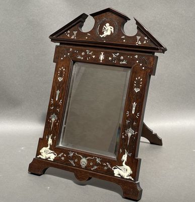 a small mirror with a wooden frame on a stand
