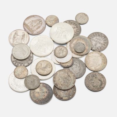 une pile de vieilles pièces d'argent sur une surface blanche