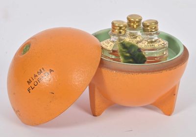 une orange posée dans un bol muni d'un couvercle