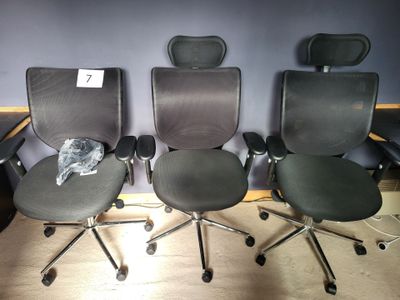 trois chaises de bureau posées côte à côte sur le sol