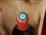 two bottles of wine in a wooden box on a table