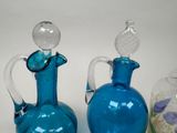 three blue glass vases sitting next to each other on a table