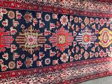 an oriental rug on the ground with a cat laying on it