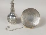 un plateau en argent et un vase en argent posés sur une table