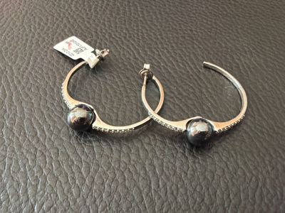 un gros plan sur une paire de boucles d'oreilles posées sur une surface en cuir