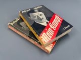 trois livres sont empilés sur une table