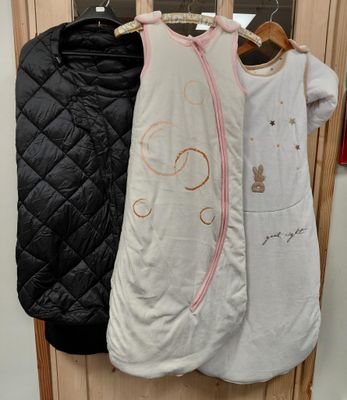 trois sacs de couchage pour bébé accrochés au mur