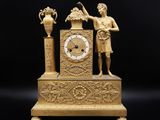une image représentant une horloge en or sur laquelle figurent un homme et une femme
