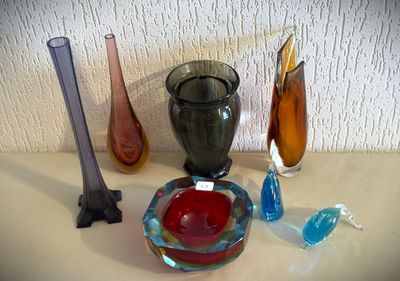 de nombreux vases en verre de différentes couleurs sur la table