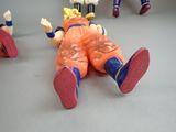 toy figurines of a kid laying on a table with other toys