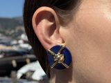 a close up of a woman wearing a pair of earrings