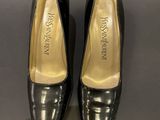 a pair of women ' s black shoes on display in a glass case