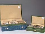 two boxes with silverware in them sitting on a table