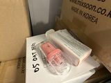 a box of pink nail polish sitting on top of a pile of boxes