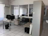 un sol carrelé de blanc dans une pièce où se trouvent un bureau et deux écrans d'ordinateur