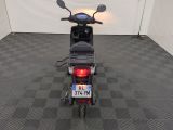 a scooter that is parked in a room with a checkered floor