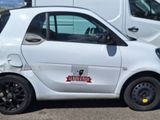 a small white car that is parked on the side of the road