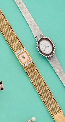 deux montres et une paire de boucles d'oreilles posées sur un fond bleu
