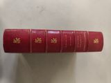 three red books sitting on top of each other on a table