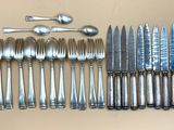 beaucoup de cuillères et de couteaux en argent sur la table