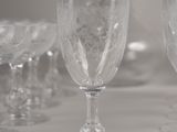 many wine glasses sitting on a table with a vase