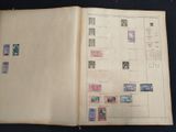 an open book with stamps on it on a table