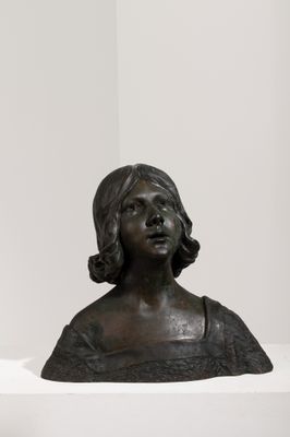 buste en bronze représentant une femme en robe noire, assise sur une étagère blanche