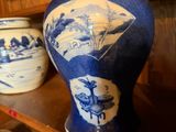 some blue and white vases are on a shelf in a room