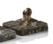 a statue of a dog sitting on top of a stone block