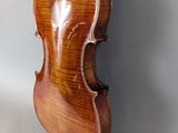 an old violin hanging on a wall with a white background