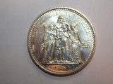 a silver coin with a picture of a woman and a man on it