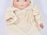 a baby doll that is sitting on a white surface