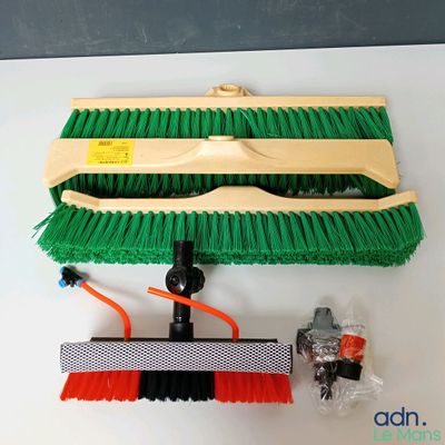 une photo représentant un balai et une brosse posés sur une table