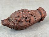 un vieux bateau en bois orné de sculptures, posé sur une table