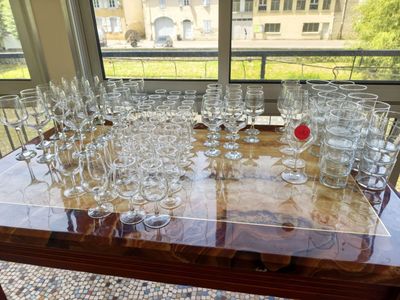 bottles and glasses on a table with a view of a building