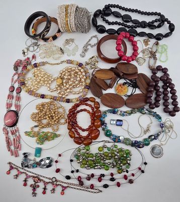 many different types of bracelets and necklaces laid out on a table