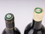 two bottles of wine sitting next to each other on a table