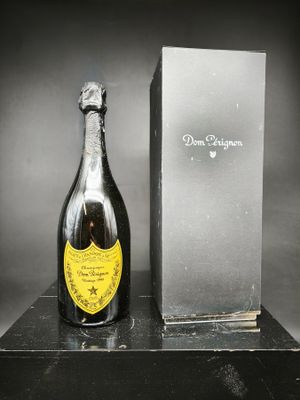 une vieille bouteille de champagne posée à côté d'une boîte sur une table