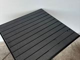 a close up of a black table on a concrete floor