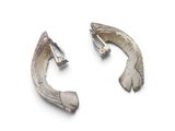 pair of silver earrings on a white surface with a white background