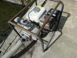 une pompe à eau posée par terre à côté d'un tuyau d'arrosage